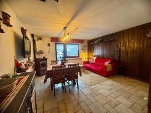 a living room with a red couch and a table at Maison au Soleil in Valtournenche
