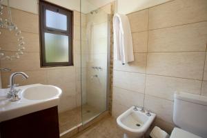 a bathroom with a shower and a sink and a toilet at Hotel Las Cascadas in La Cumbrecita +82 photos