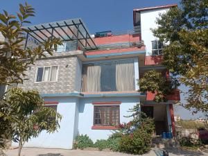 a white house with red windows and trees at Le Petit Paradis Nepal Terrace & Mountain View in Pātan