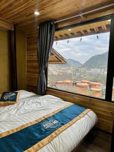 a bedroom with a bed and a large window at Mây Đá Homestay in Loung Co