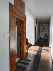 a hallway with a wooden door in a house at GG Residency INN in Palakkad