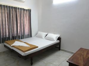 a bed in a room with a curtain and a bed sidx sidx sidx at GG Residency INN in Palakkad