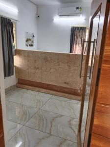 a bathroom with a marble floor and a glass door at GG Residency INN in Palakkad