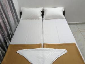 two beds with white sheets and pillows in a room at GG Residency INN in Palakkad