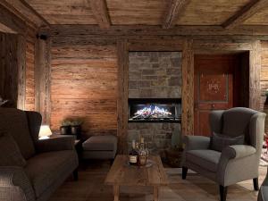 a living room with a fireplace with a tv at Hotel Gran Fanes in Corvara in Badia