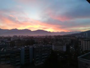 a sunset over a city with mountains in the background at X1 Chambre appartement T3 cohabitation partie commune et salon in Chambéry