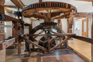 a woodenmill wheel in a room with wooden floors at Arlington Mill in Bibury