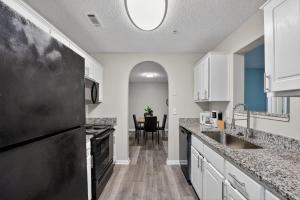 a kitchen with white cabinets and a black refrigerator at Stylish 2BR2BA with room to unwind in Stockbridge