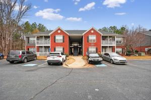 a large red house with cars parked in a parking lot at Stylish 2BR2BA with room to unwind in Stockbridge