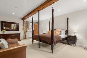 a bedroom with a four poster bed and a couch at Arlington Mill in Bibury