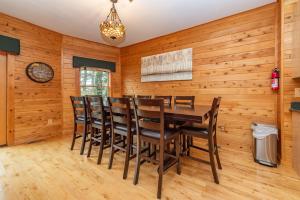 a dining room with wooden walls and a table and chairs at Cedar Shores Villa #06 by Railey Vacations in McHenry