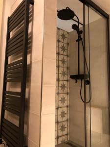 a glass shower door with a lamp next to a wall at TrailHouse in Liptovský Mikuláš