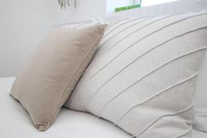 a pillow sitting on top of a bed at Rustic Retreat Opposite Stadium in Cardiff