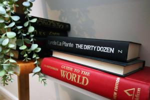 a stack of books sitting on top of a shelf at Rustic Retreat Opposite Stadium in Cardiff