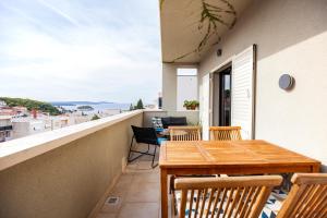 a balcony with a wooden table and chairs at Apartmani Vale in Hvar