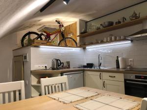 a kitchen with a table and a bike on the wall at TrailHouse in Liptovský Mikuláš