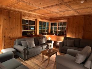 a living room with two couches and a table at Hotel Gran Fanes in Corvara in Badia