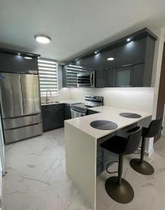 a kitchen with black cabinets and a white counter top at Luxury Apartment- 3 Bedrooms in Ceiba