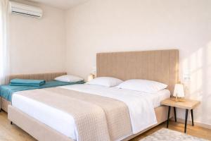 a bedroom with a large white bed and a table at Vila Eva in Golem