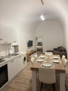a kitchen and living room with a table and chairs at Vicolo Lungo Apartment in Nardò +8 photos