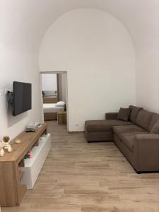 a living room with a couch and a television at Vicolo Lungo Apartment in Nardò