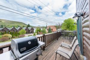 a patio with a grill and chairs on a deck at Cedar Shores Villa #19 by Railey Vacations in McHenry