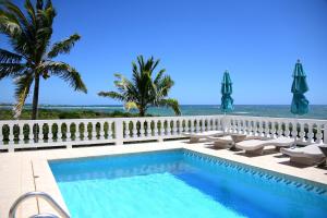 a swimming pool with a view of the ocean at Lockrum Point Villa - Upscale Ocean Front, Pool with Gazebo in South Hill Village