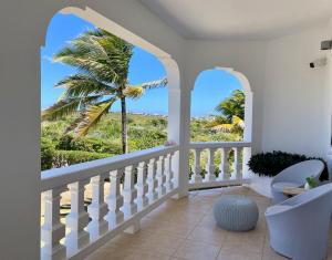 a room with a balcony with a palm tree at Lockrum Point Villa - Upscale Ocean Front, Pool with Gazebo in South Hill Village