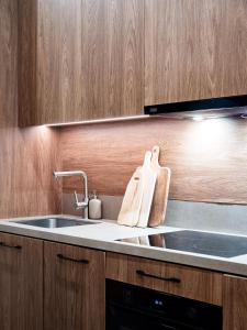 a kitchen with a sink and wooden cabinets at LookTatry Tatra Stone House z Jacuzzi in Kościelisko