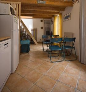 a kitchen with a table and chairs and a refrigerator at Le refuge de la Fée - centre et plage in Fouras