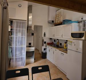 a kitchen with white cabinets and chairs in it at Le refuge de la Fée - centre et plage in Fouras +6 photos