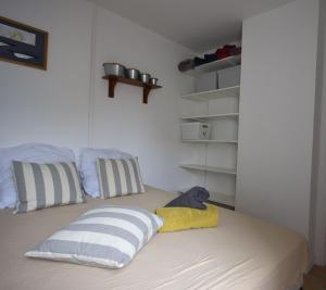 a bed with two pillows and a stuffed animal on it at Le refuge de la Fée - centre et plage in Fouras