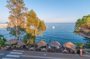 a group of tables and chairs next to the water at Hotel Ristorante La Conchiglia in Cala Gonone