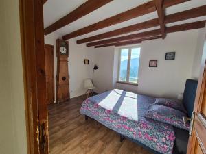 a bedroom with a bed and a clock on the wall at Maison au calme en Chartreuse in Miribel-les-Échelles