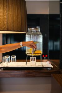 a person is pouring a drink into two glasses at Cidnay - Hotel & Executive Center in Santo Tirso
