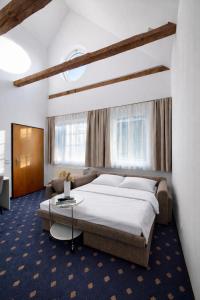 a bedroom with a large bed and a couch at Stadthotel Kramer in Villach +67 photos
