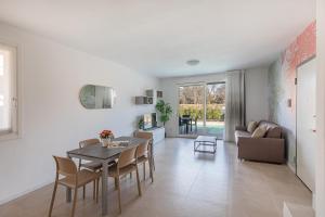 a dining room and living room with a table and chairs at Villa Prestige in Sirmione