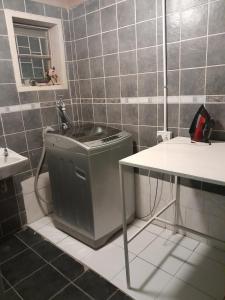 a bathroom with a sink and a trash can at Dudes guesthouse in Francistown
