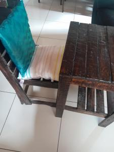 a wooden bench sitting on the floor next to a table at Dudes guesthouse in Francistown