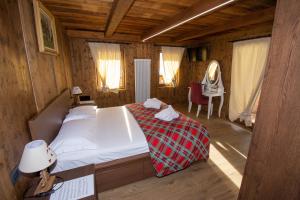 a bedroom with a bed in a wooden room at B&B LE TERZE - Wellness & SPA - E-bike rental in Costalta