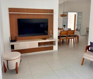 a living room with a flat screen tv on a wall at Casa espaçosa com piscina, a 2 quadras do mar! in Guaratuba