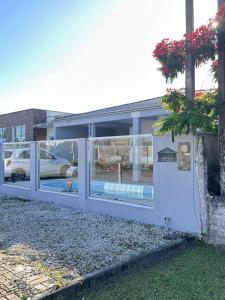 a building with glass windows and a fence at Casa espaçosa com piscina, a 2 quadras do mar! in Guaratuba