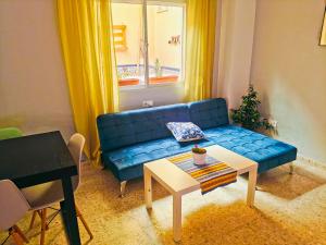 a living room with a blue couch and a table at Maracuya House - Men Only in Torremolinos