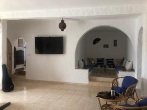 a living room with a tv on a wall at Villa Thalassa in Oualidia