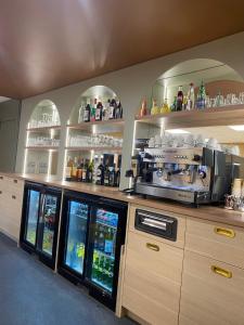 a kitchen with a bar with alcohol bottles on shelves at Green Hôtels Poitiers in Poitiers +13 photos