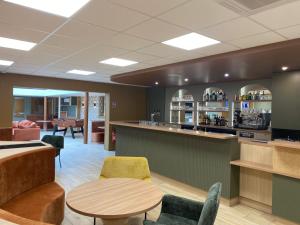 a lobby with a bar and a table and chairs at Green Hôtels Poitiers in Poitiers