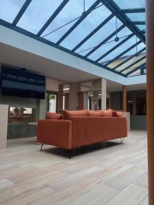 a couch in a living room with a glass ceiling at Green Hôtels Poitiers in Poitiers