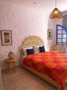 a bedroom with a bed with a red comforter at Villa Thalassa in Oualidia