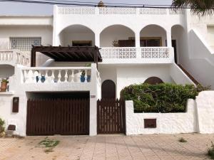 a white house with a gate and a balcony at Villa Thalassa in Oualidia