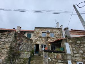 an old stone house with a stone wall at Casa Martins by Tear in Aldeia de João Pires